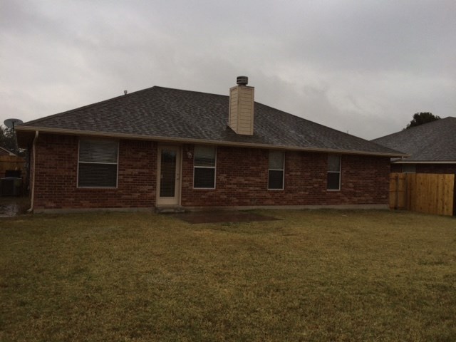 a brick house with a yard and a wood fence