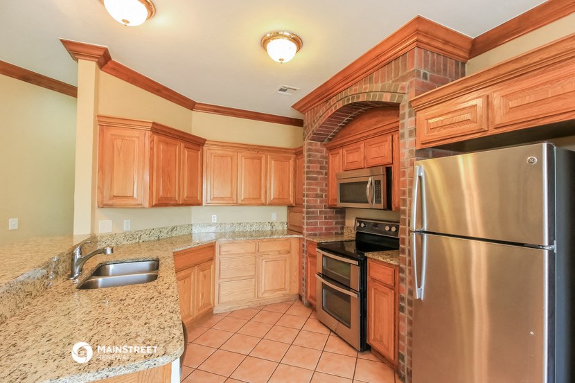a kitchen with wooden cabinets and stainless steel appliances