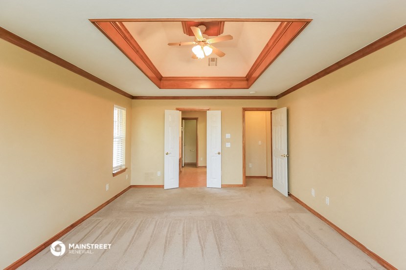 a empty living room with a ceiling fan