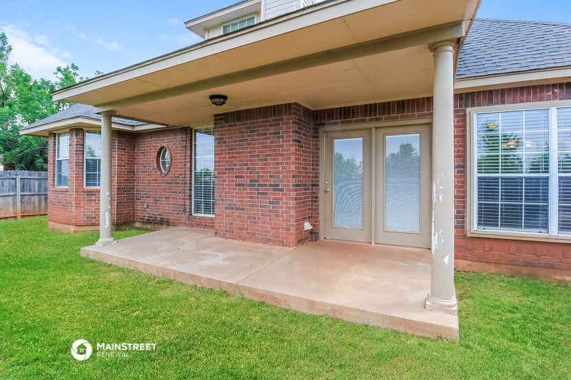 the front porch of a brick house with two doors