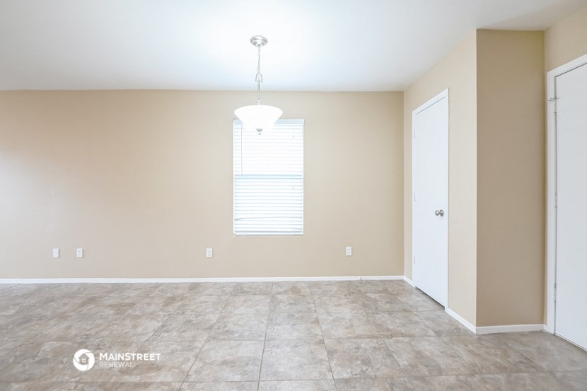 a empty living room with a large window and a door