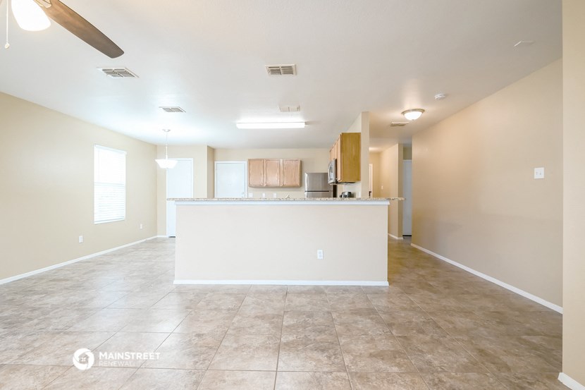 the living room and kitchen of an empty house
