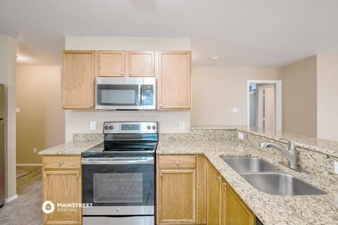 a kitchen with granite counter tops and wooden cabinets