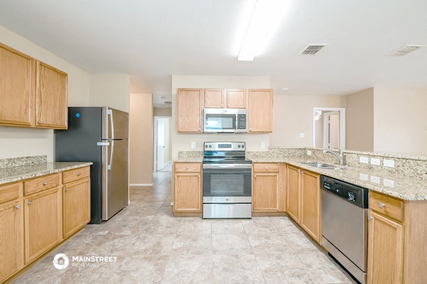 a kitchen with wooden cabinets and stainless steel appliances