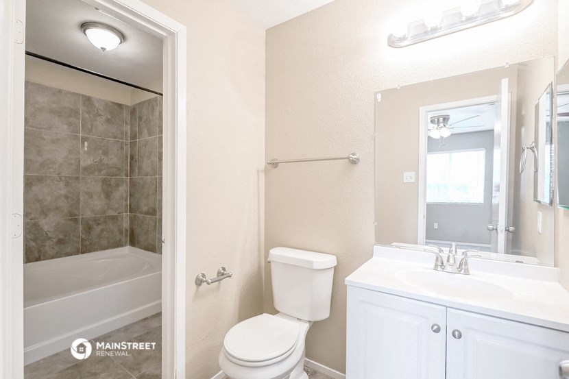 a white bathroom with a toilet and a tub and a sink