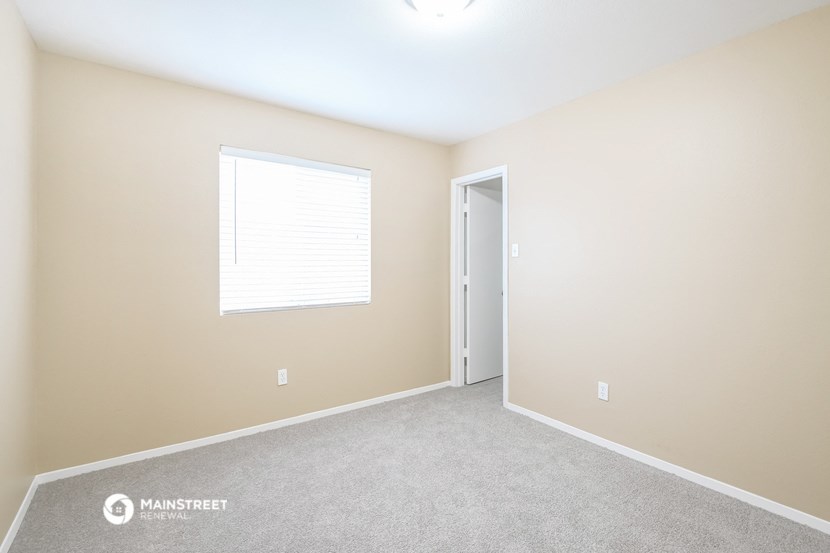 a room with carpet and a window and a door