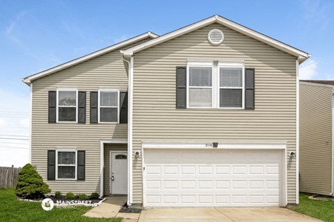 a tan house with a white garage door