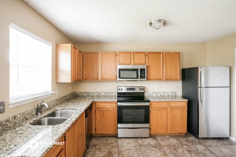 a kitchen with wooden cabinets and stainless steel appliances