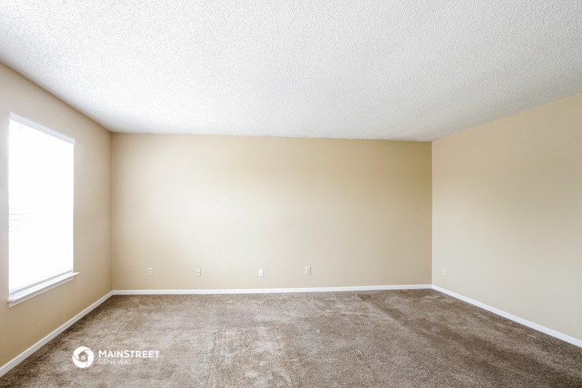 an empty room with carpet and a window