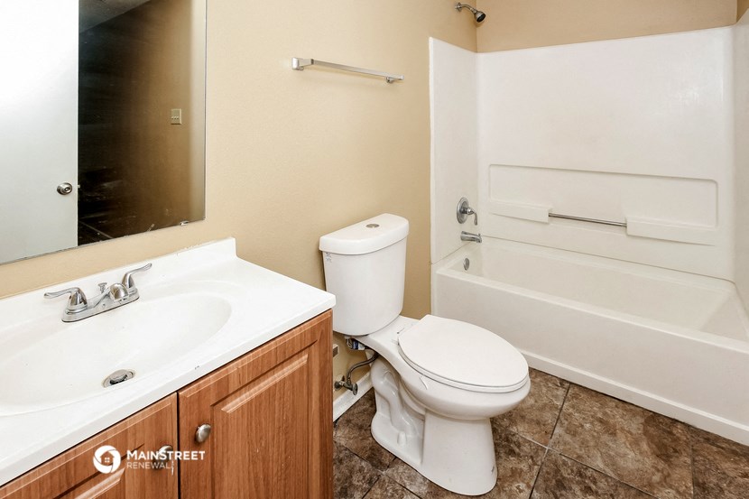 a bathroom with a toilet and a sink and a bath tub