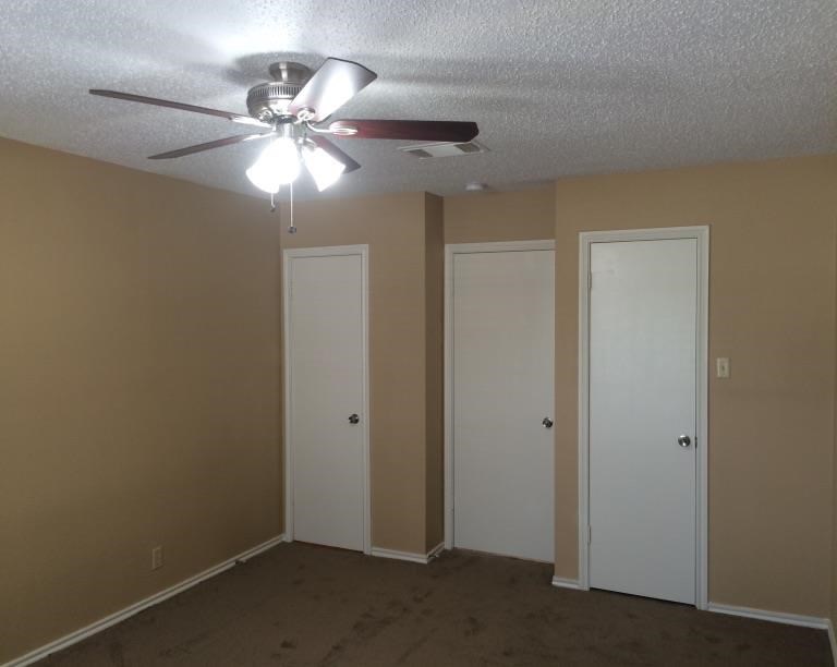 a living room with a ceiling fan and two doors