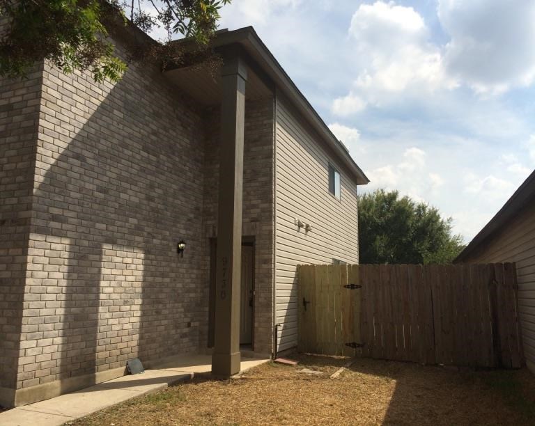 a brick house with a wooden fence