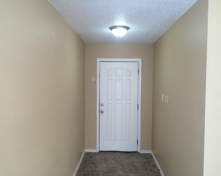 a room with a white door and a ceiling light