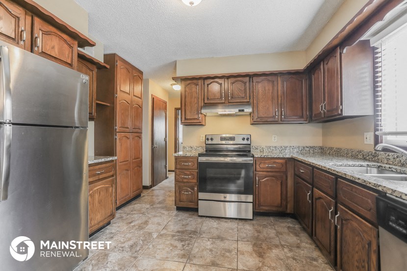 a kitchen with wooden cabinets and stainless steel appliances