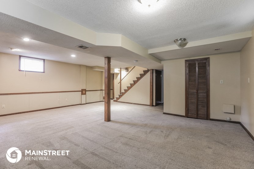 the living room and dining room of a house with white walls and a carpet floor