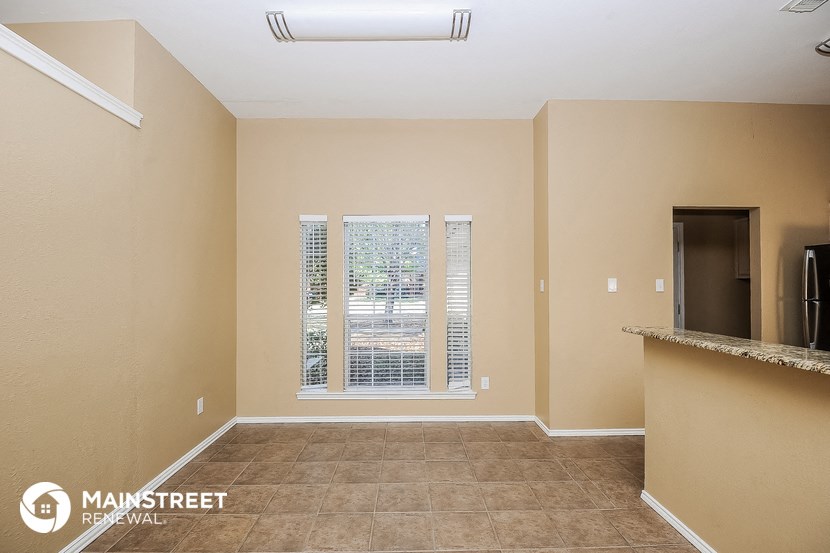 the kitchen and living room of a home with a large window