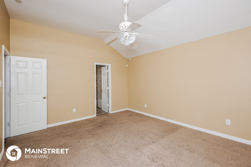 a bedroom with a ceiling fan and a white door
