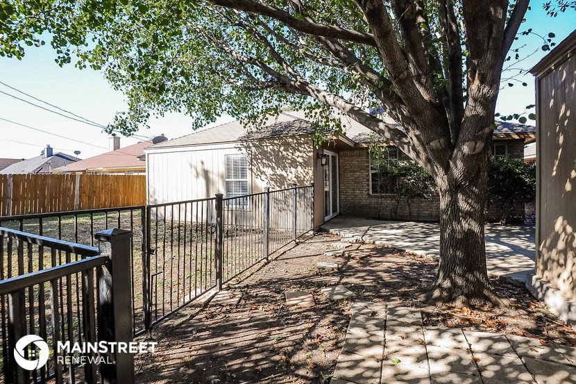 a fenced in yard with a tree and a fence