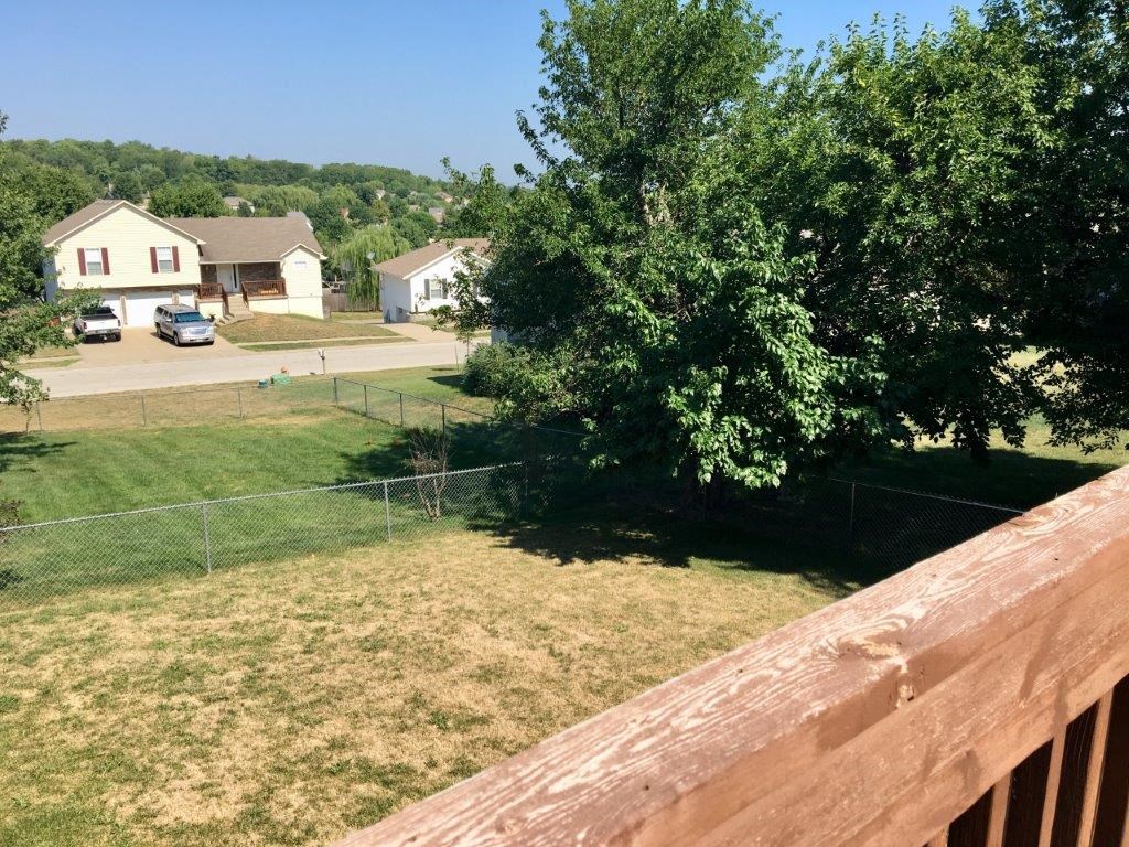 a view of a backyard from a deck with a fence