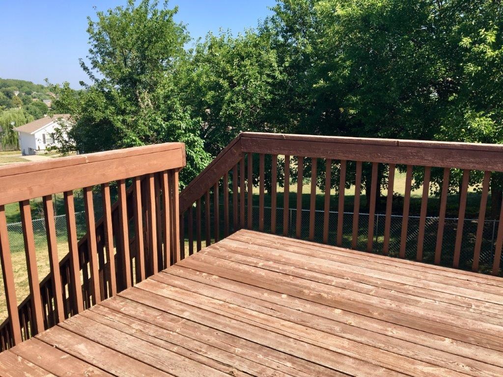 a deck with a view of a yard and trees