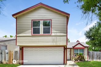 a tan house with a white garage door and a red trim
