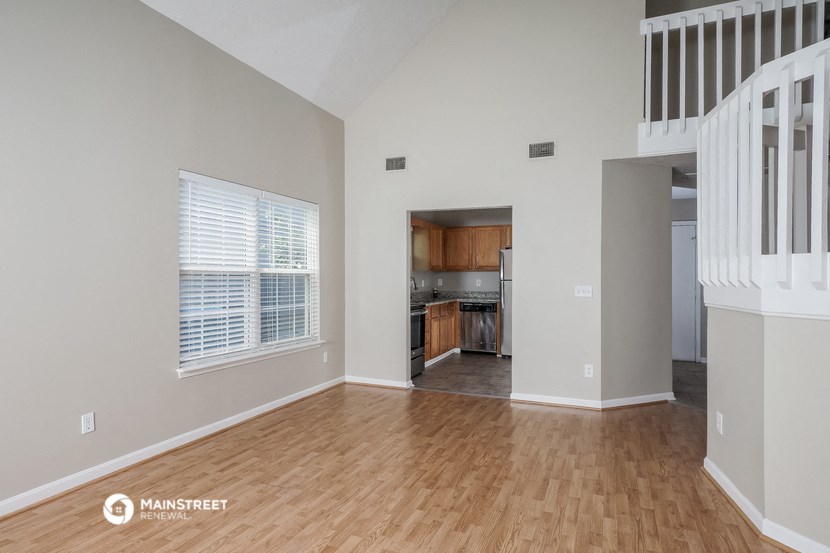 the living room and kitchen of an empty house