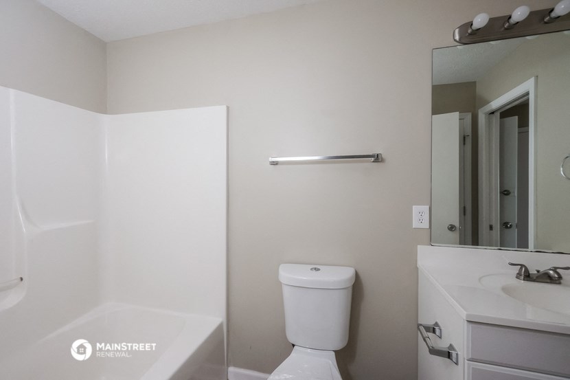 a bathroom with a toilet and a sink and a mirror