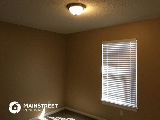 a bedroom with a window and a light on the ceiling