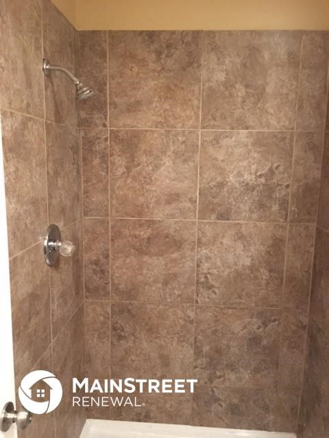 a bathroom with a shower and a tile floor