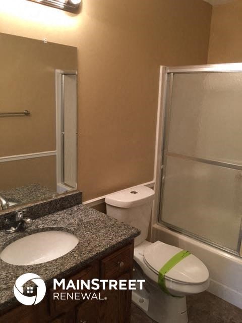 a bathroom with a toilet and a sink and a shower