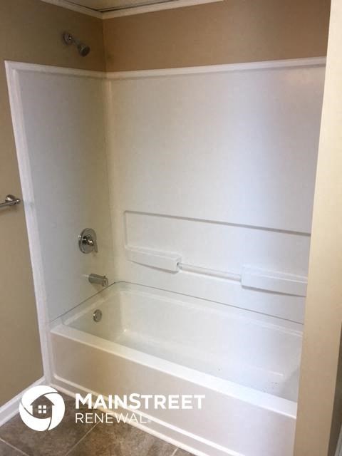 a white bathroom with a white tub and a sink