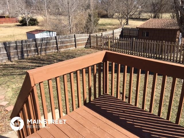a wooden railing on a deck in a backyard