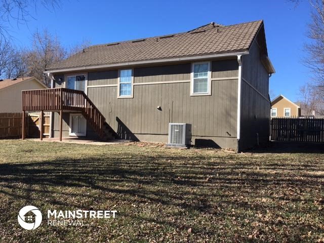 the back of a house with a yard and a deck