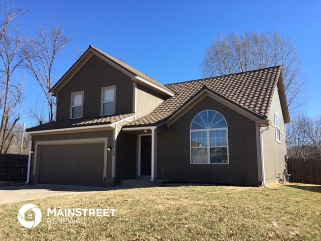 a brown house with a lawn in front of it