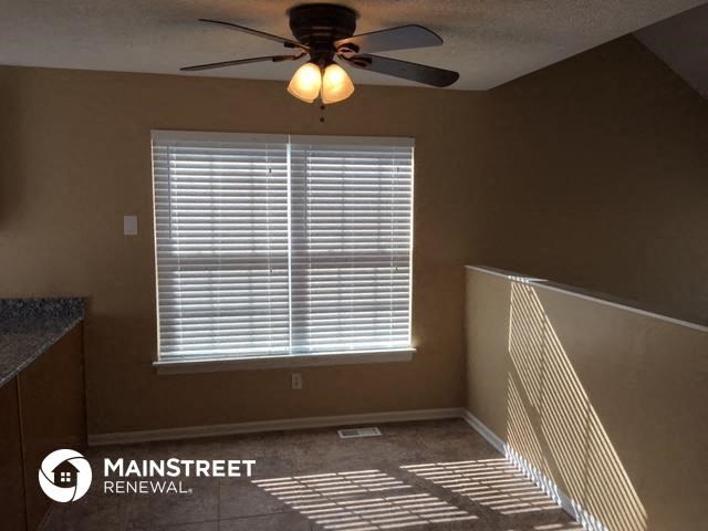 a living room with a ceiling fan and a window