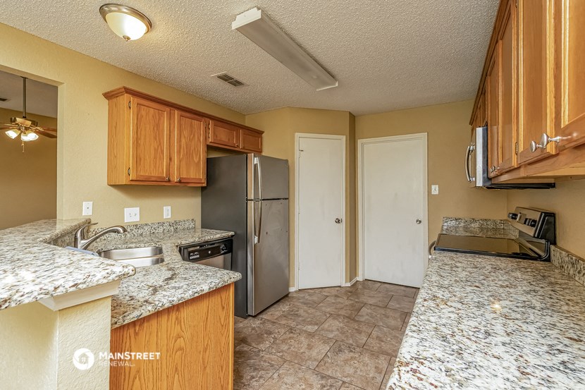 the kitchen has granite counter tops and stainless steel appliances