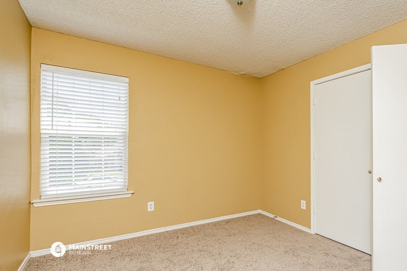 an empty room with a window and a door