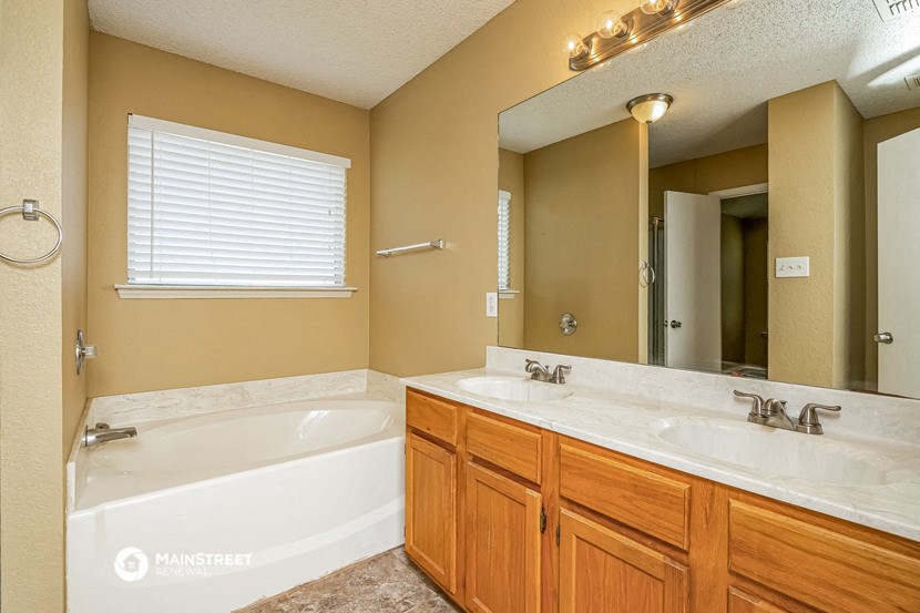 a bathroom with a tub and a sink and a mirror