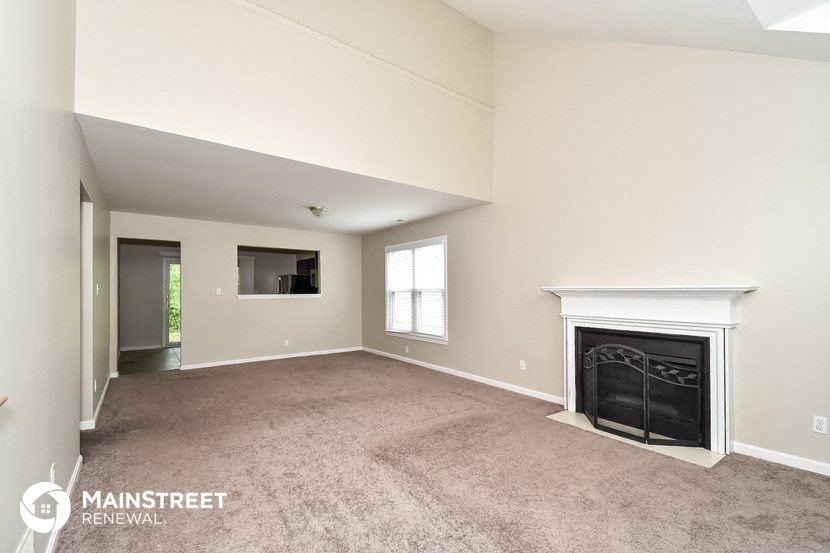 a living room with a fireplace and a carpeted floor