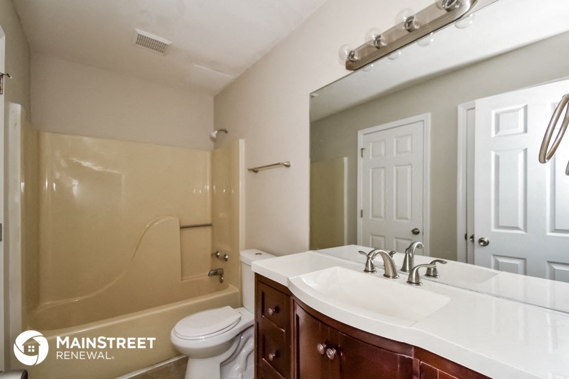 a bathroom with a white sink and a toilet and a shower