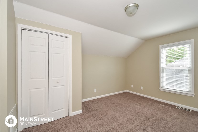 a bedroom with a carpeted floor and a white closet