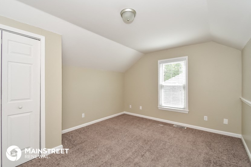 the upstairs bedroom with carpet and a white door