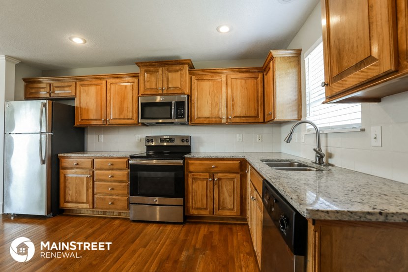 a kitchen with wooden cabinets and stainless steel appliances