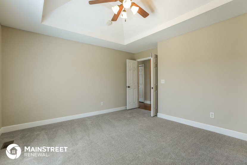 a living room with carpet and a ceiling fan