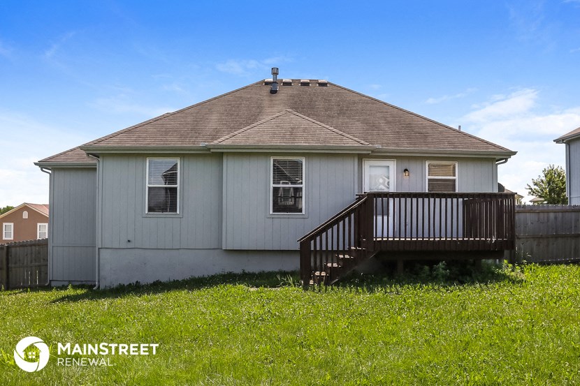 a small white house with a deck in front of it