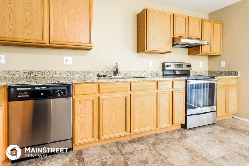 a kitchen with wooden cabinets and stainless steel appliances