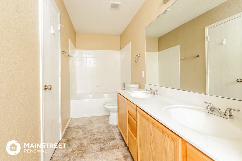 a bathroom with two sinks and a shower and a toilet