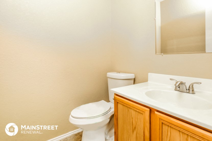 a bathroom with a toilet and a sink and a mirror
