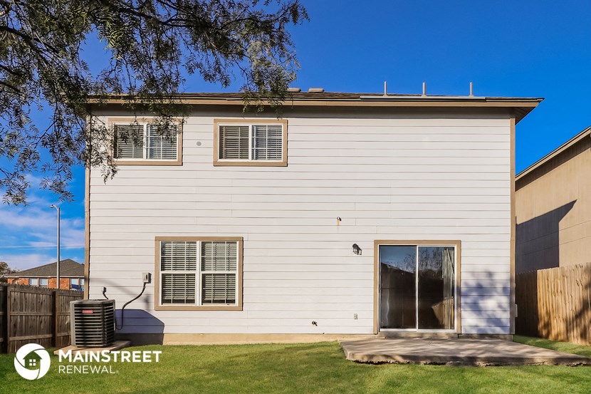 the exterior of a white house with a yard and grass