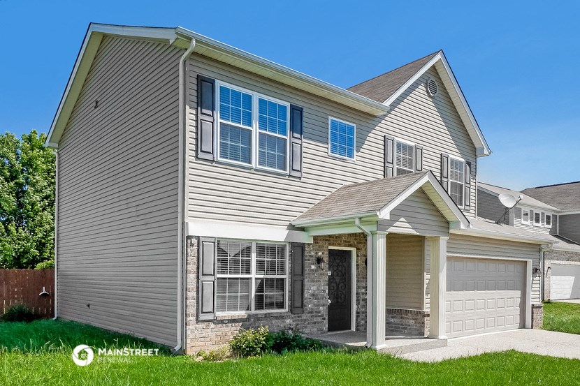 a gray house with a white garage door and a gray roof